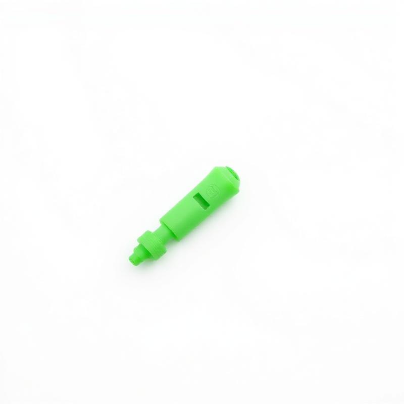 Green plastic suction bite extractor tool on a white background
